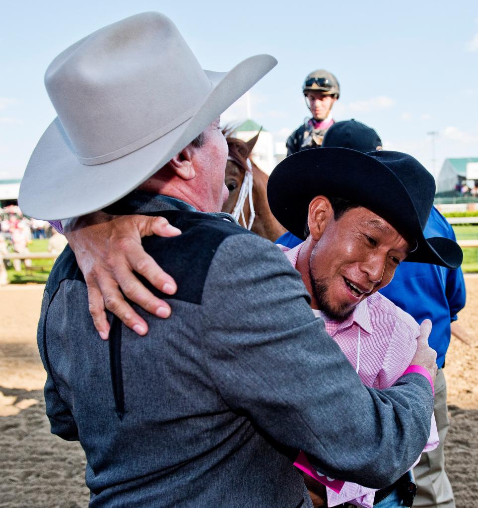 Trainer Larry Jones hugs a groom after a Kentucky Oaks win. (Eclipse Sportswire)