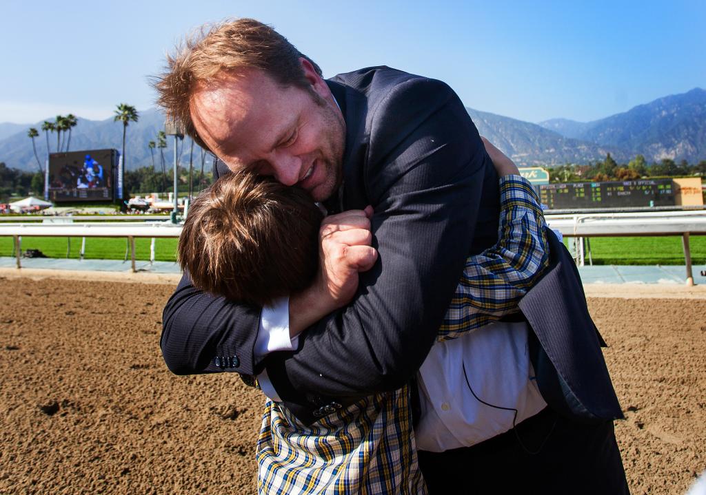 Doug O'Neill hugs his son after winning the Santa Anita Derby with Goldencents. (Eclipse Sportswire)
