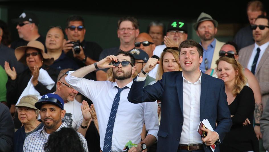 Racing fans at Santa Anita Park cheer home a winner.